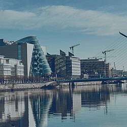 Panoramablick auf Dublin Docklands mit Samuel Beckett Bridge, modernen Bürogebäuden am River Liffey und Stadtpanorama bei blauem Himmel