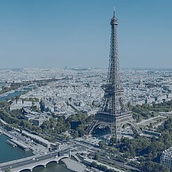 Luftaufnahme von Paris mit Eiffelturm, Seine-Ufer, Brücken und Stadtpanorama bei klarem Himmel